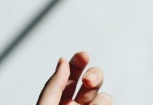 “손톱이 잘 갈라지고 울퉁불퉁해요”… 몸속 신호를 말해주는 ‘네일 건강’ persons left hand on white table