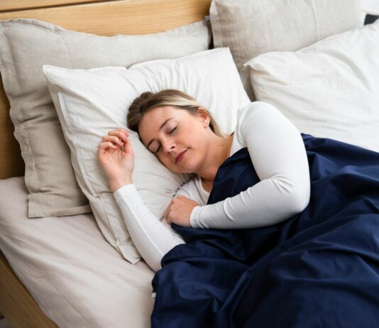 건강을 지키며 하는 다이어트 a woman sleeping on a bed with a blue blanket