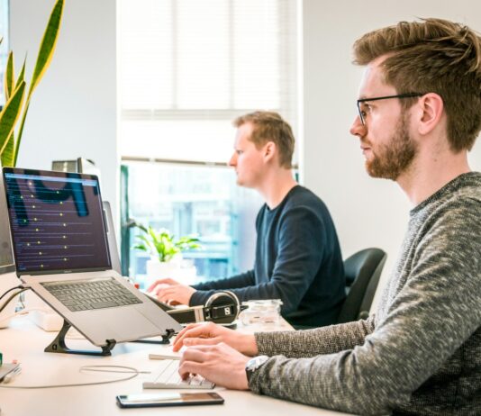 직장인 건강, 바쁜 일상 속 작은 습관이 큰 변화를 만든다 man sitting on chair wearing gray crew-neck long-sleeved shirt using Apple Magic Keyboard