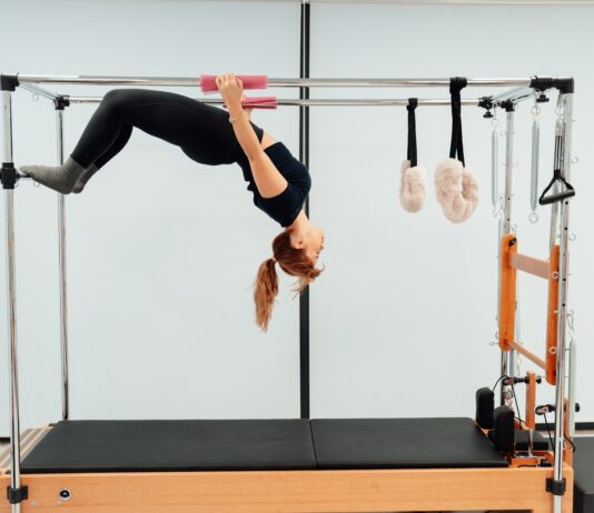 필라테스, 건강한 몸과 마음을 위한 최고의 선택 a woman doing a handstand on a pivot machine