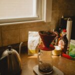 “아침 루틴이 바꾼 하루, 건강 트렌드로 떠오른 ‘슬로우 모닝’ 실천법” a coffee pot sitting on top of a scale