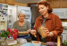 생활 속 니트(NEAT) 다이어트: 헬스장 밖에서도 칼로리를 태우는 일상 활동의 위력 Two women preparing food in a kitchen.