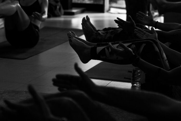 People exercising on yoga mats in a studio.