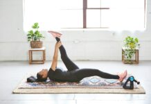 ‘웰니스 회복’의 비결, 일상에서 쉽게 실천하는 방법들 woman in black tank top and black leggings lying on black and white floral area rug